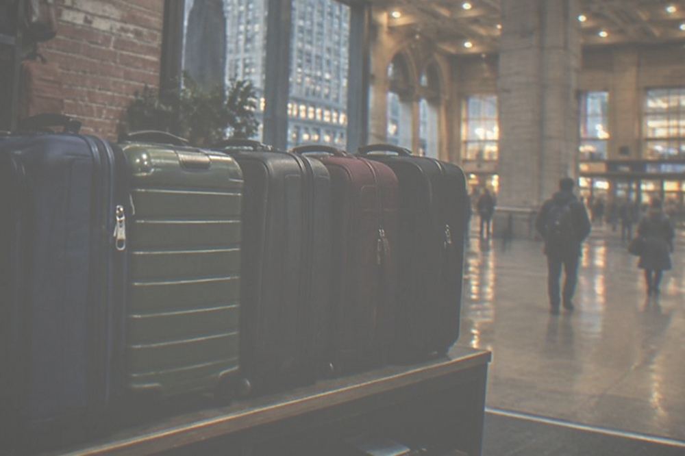 Suitcases lined up behind the counter of a small city shop offering bag storage