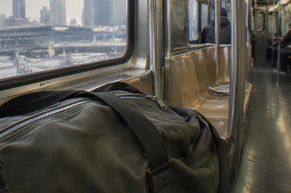 A subway car interior with overhead luggage racks and empty seats during a quiet hour