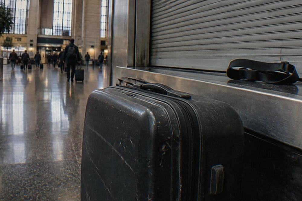 Departure hall with airline counters and an empty baggage cart parked beside a pillar