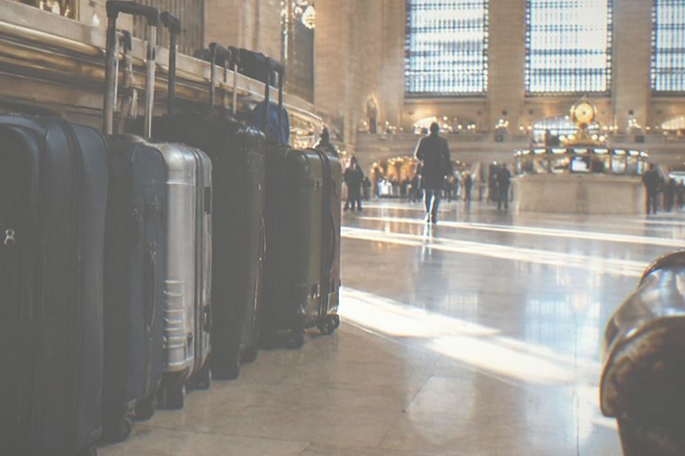 Suitcases lined up beside a seating area in a bright hall