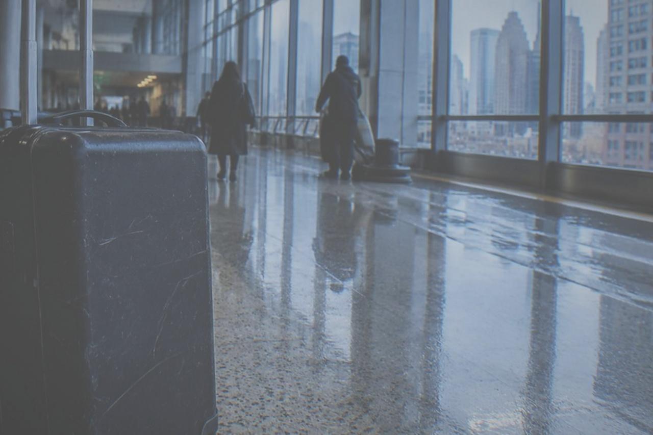 Empty airport terminal corridor with tall windows and polished floor
