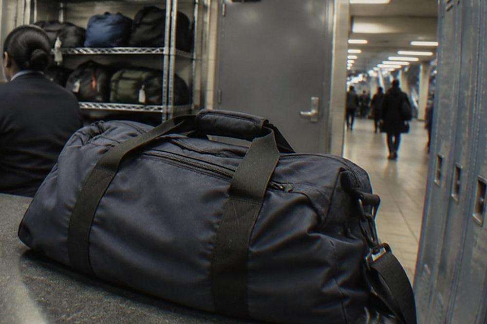 Airport baggage storage counter with a staffed desk, shelving and a closed security door