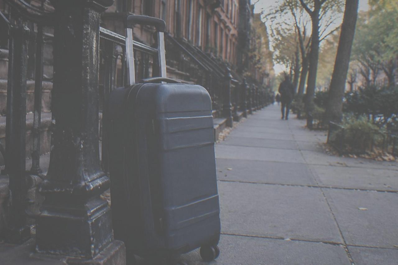 An empty Manhattan sidewalk with wide pavement and storefronts on a quiet morning
