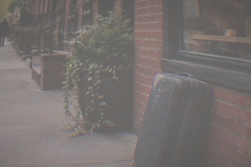 A suitcase leans against the shopfront of a New York neighbourhood store, ready to be handed to staff at a Radical Storage partner counter inside.