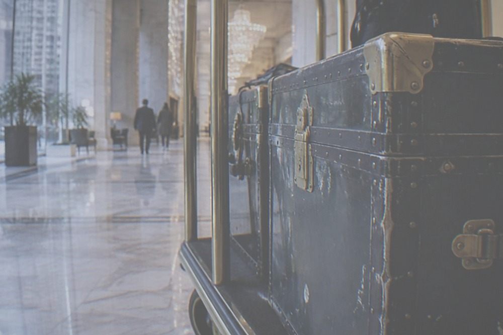 A large suitcase waiting beside a hotel luggage trolley in a bright lobby