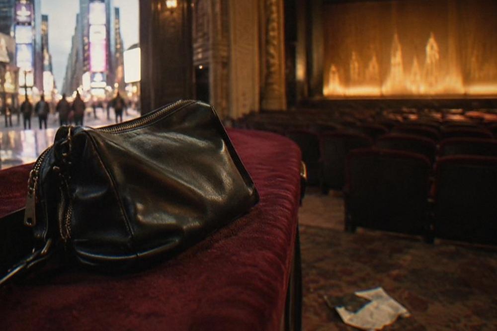 Empty theatre seats facing a lit stage before a performance
