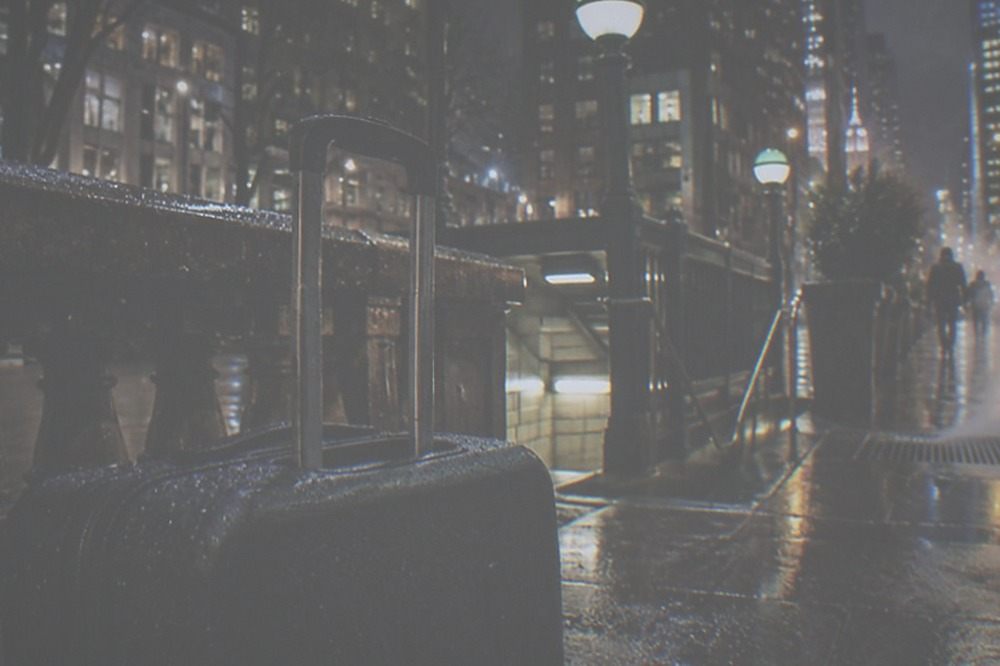 A night-time station entrance with lit signage and an empty sidewalk