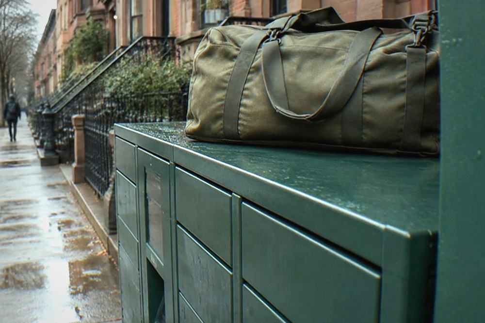 Row of green parcel lockers built into a New York sidewalk