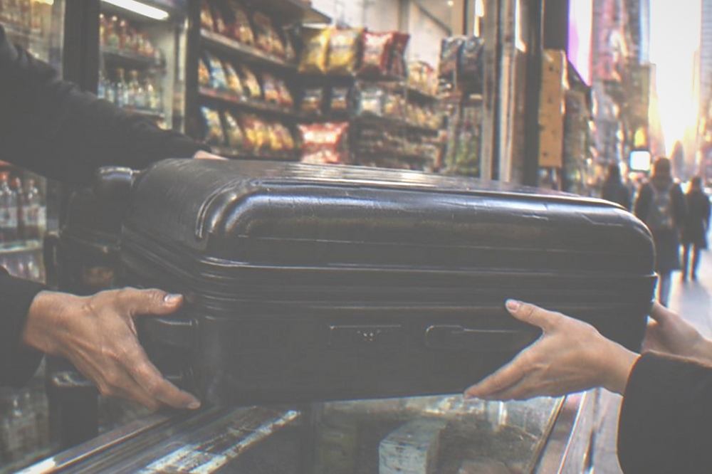 Shop counter with a suitcase being handed over a display case