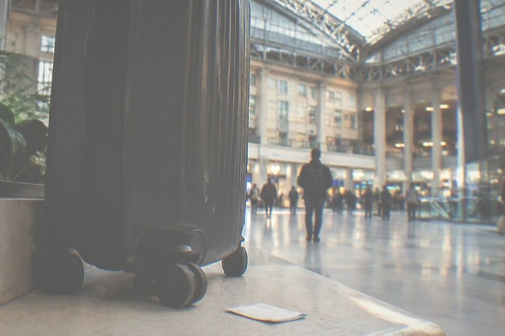 Moynihan Train Hall interior with travelers and luggage