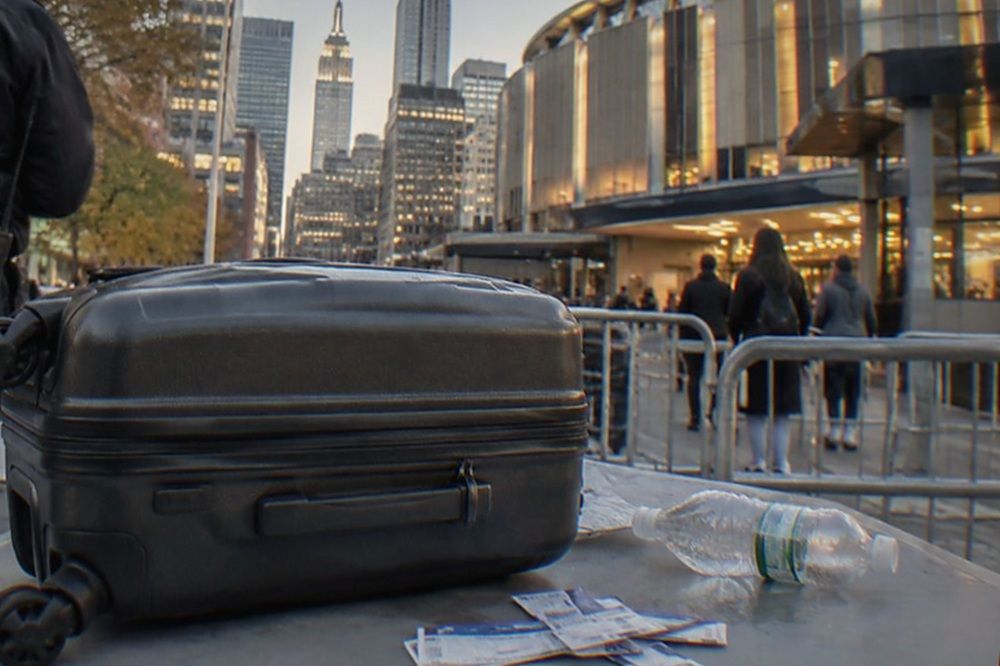 A crowded entrance plaza outside a Manhattan arena with security screening tables set up near the doors