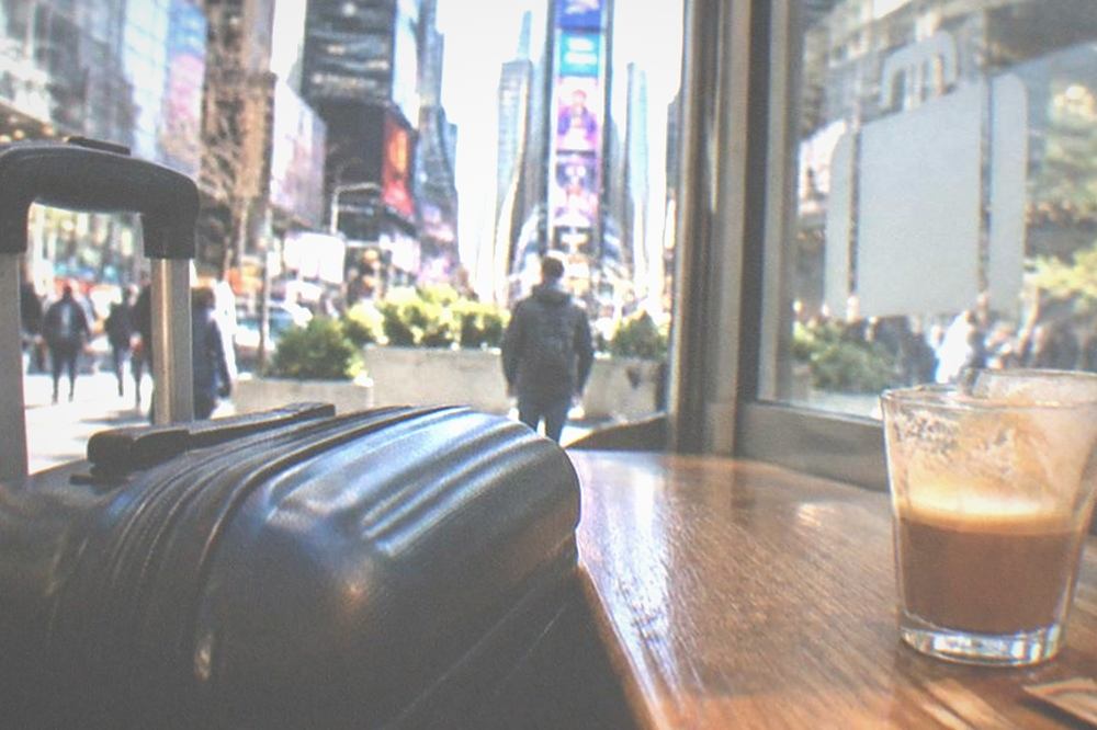 Suitcase parked beside a café counter with a storage point sign in the window