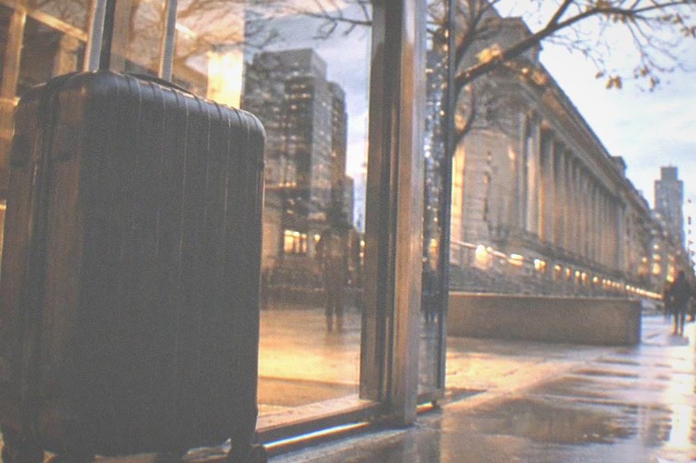 Station entrance at dusk with glass doors and a lit sign above them