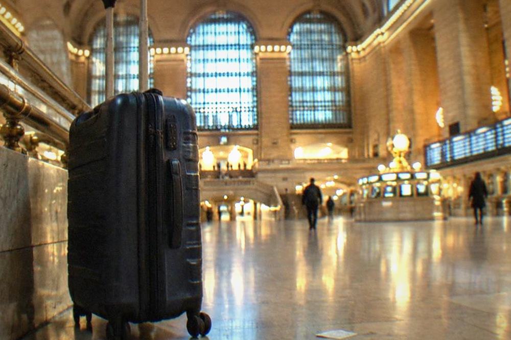 Empty concourse corridor in a train station with departure boards overhead and no luggage in sight