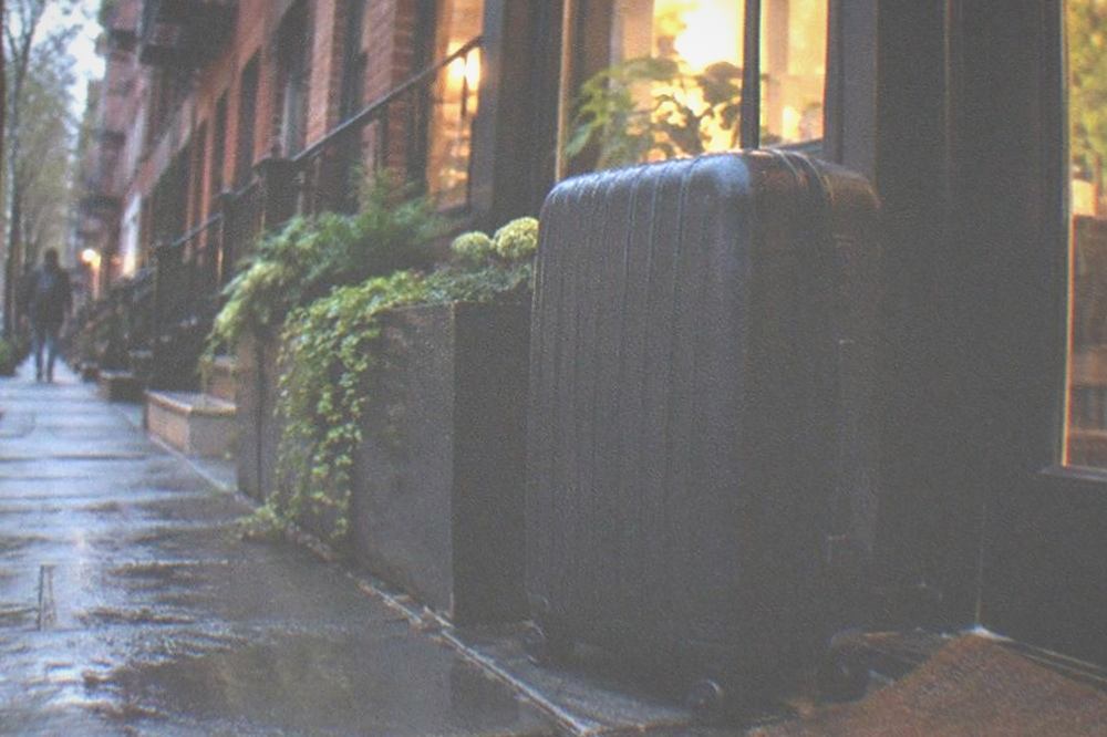 City street at dusk with a lit shopfront and a closed sign on the door