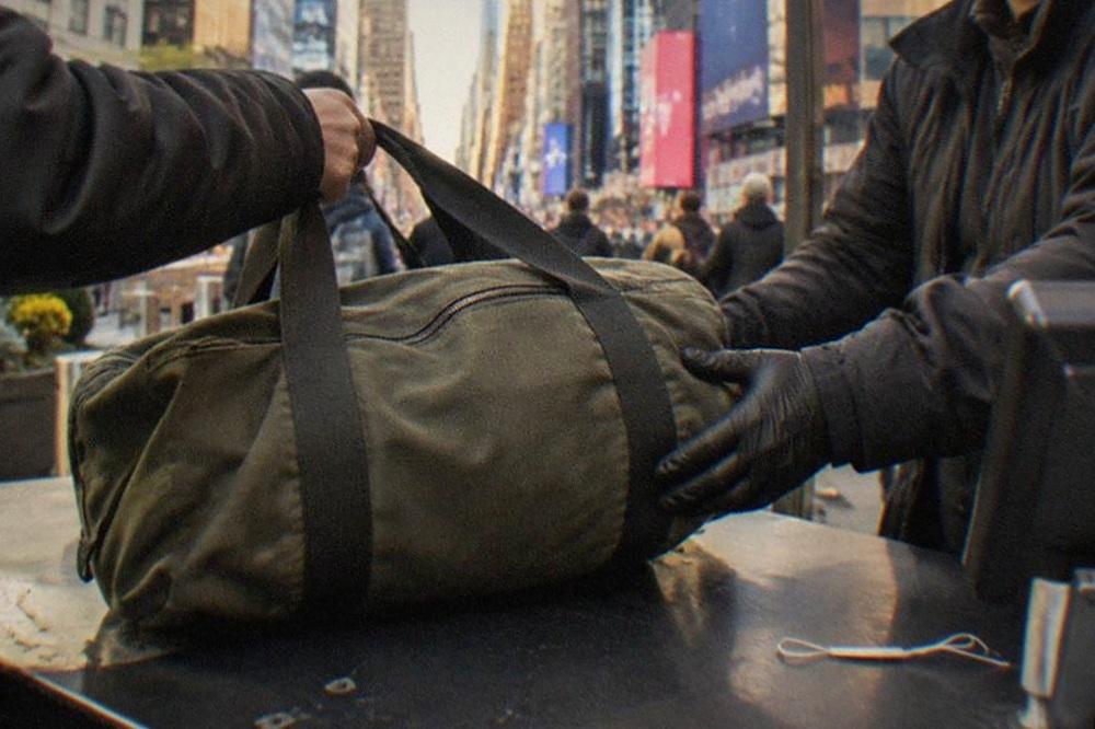 A traveller handing a suitcase across a staffed shop counter in Manhattan