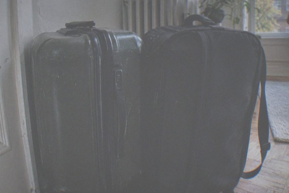 Two suitcases waiting by the door of a New York apartment on a bright afternoon