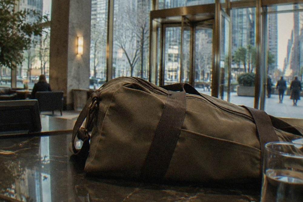A hotel lobby front desk in the morning with a suitcase parked beside it