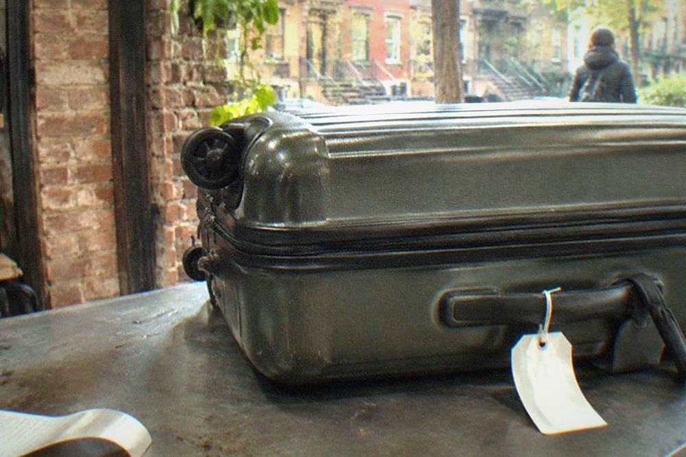 A shop counter with a tagged suitcase behind it and a receipt on the counter